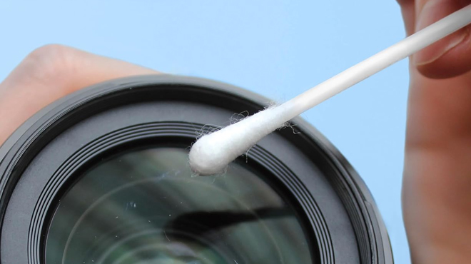 A person using a Q tips Cotton Swabs to clean a camera lens