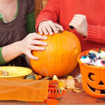 People carving a Pumpkin with Hansgo Pumpkin Carving Kit 22 Piece Set