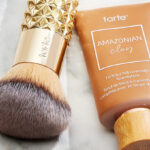 Tarte Amazonian Clay 16 Hour Foundation with Golden Era Brush on a Table