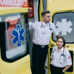 Two Paramedics standing in front of an Ambulance Car