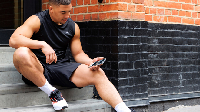 Young guy looking at Reeboks fitness app