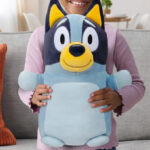 A Child Holding the Squishmallows Official Plush 14 inch Bluey Hugmee