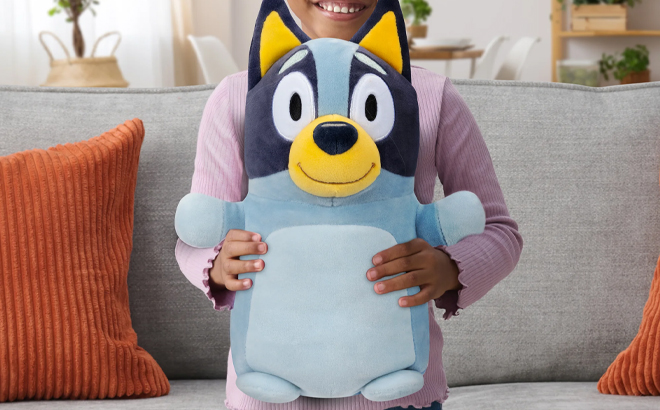 A Child Holding the Squishmallows Official Plush 14 inch Bluey Hugmee