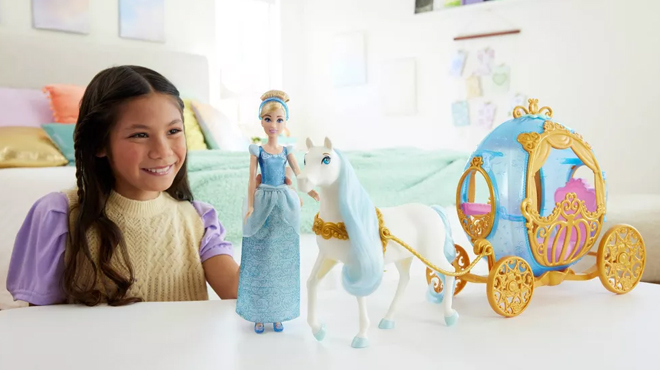 A Girl PLaying with Disney Princess Cinderella Rolling Carriage Horse Set