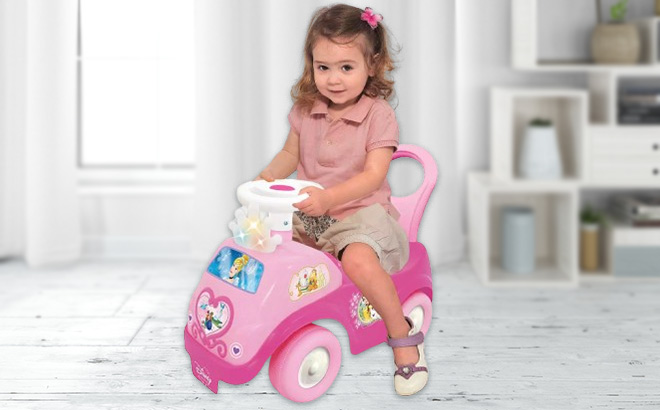 A Girl is Driving the Trademark Global Disney Princess Lights Sounds Ride On Toy