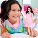 A Kid Holding Barbie Fashionistas Doll