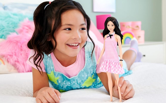 A Kid Holding Barbie Fashionistas Doll