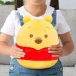 A Kid Holding Squishmallows Disney Winnie the Pooh Toy