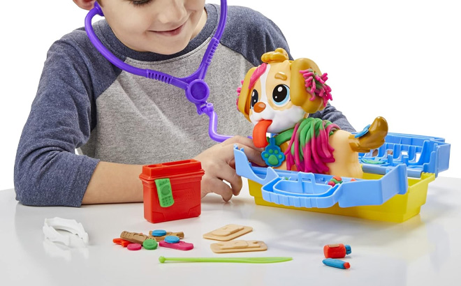 A Kid is Playing with Play Doh Care n Carry Vet Playset