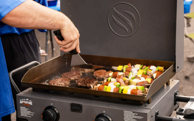 A Person Cooking Kebab Using a Blackstone Adventure Griddle