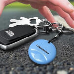 A Person Grabbing for the Tracker Keychain on Keys on the Road