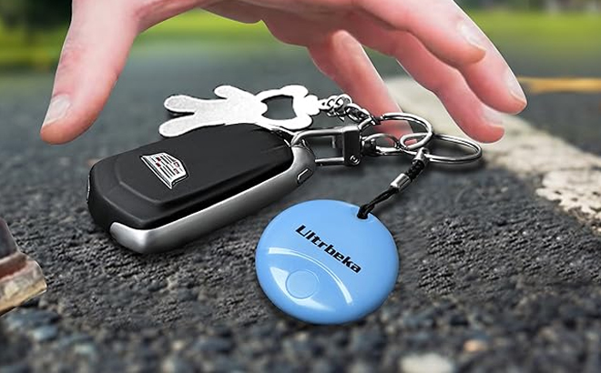 A Person Grabbing for the Tracker Keychain on Keys on the Road