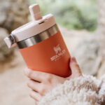 A Person Holding Stanley The IceFlow Flip Straw Tumbler in Tigerlily Color