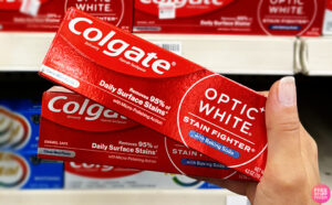 A Person Holding Two Colgate Optic White Toothpaste