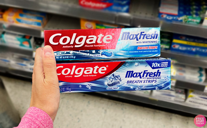 A Person Holding Two Colgate Toothpastes