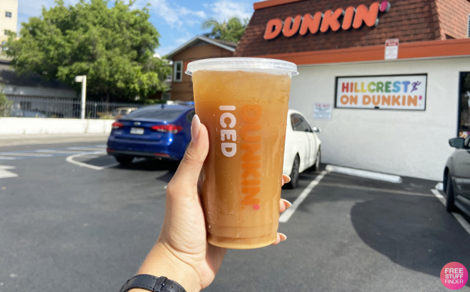 A Person Holding a Dunkin Coffee in Front of the Store