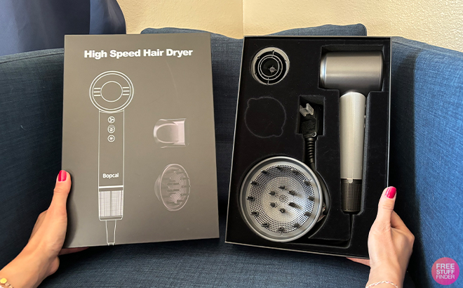 A Person Holding the Bopcal Ionic Hair Dryer with a Diffuser on a Couch