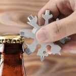 A Person Opening a Bottle Using a Snowflake Multitool