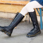 A Person Wearing Dr Martens 1B60 Bex Pisa Leather Knee High Boots