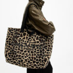 A Person carrying an All Saints Izzy Leopard Print Logo Tote Bag