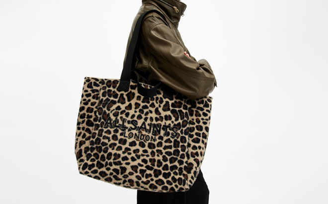 A Person carrying an All Saints Izzy Leopard Print Logo Tote Bag