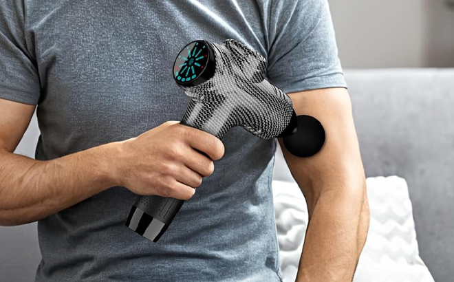 A Person holding a Raemao Massage Gun