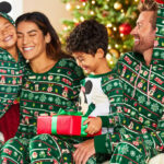 A Smiling Family in Green Matching Disney Holiday Pajamas