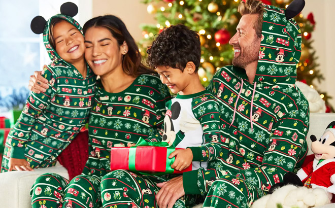 A Smiling Family in Green Matching Disney Holiday Pajamas