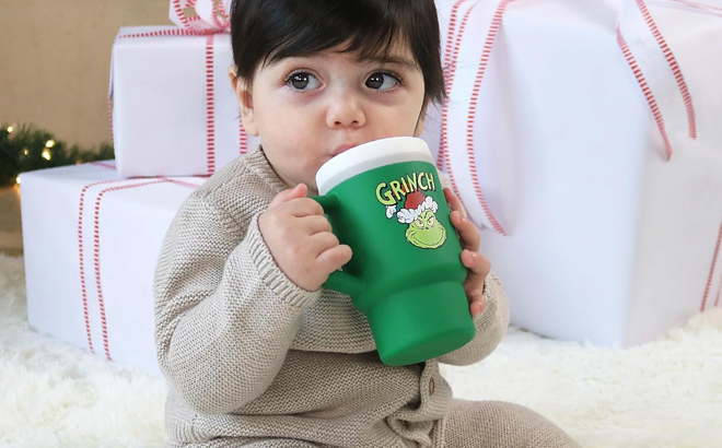 A Toddler Drinking from the Infantino Green Grinch Limited Edition My 1st Tumbler