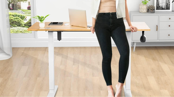 A Woman Leaning on the Smug Electric Standing Desk