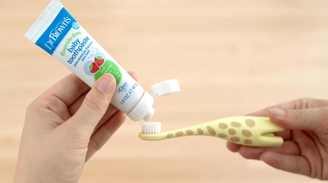 A Woman Using the Dr. Brown's Infant to Toddler Training Toothbrush with Toothpaste Set