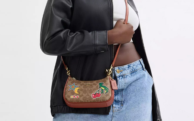 A Woman Wearing Coach Outlet Teri Mini Crossbody Bag In Signature Canvas with Sticker Print