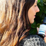 A Woman with Healty Long Hair Holding a Happy Head Hair Serum