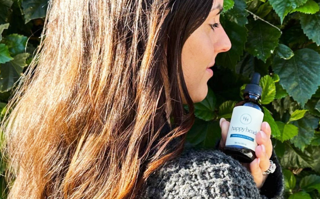 A Woman with Healty Long Hair Holding a Happy Head Hair Serum