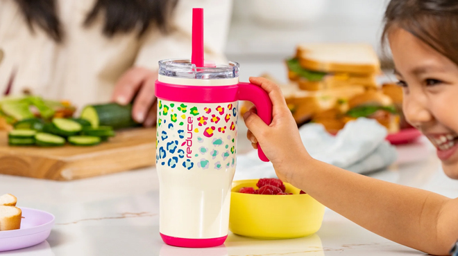 A child holding a Reduce Coldee Kids 18 oz Tumbler