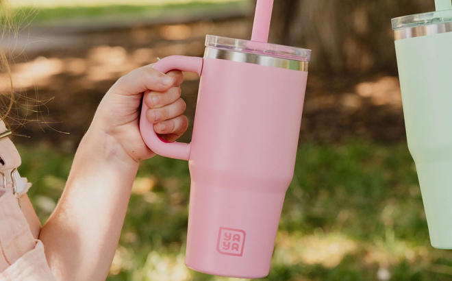 A child holding a YAYA My First Travel Tumbler for Toddlers