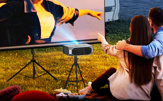 A couple watching a movie outdoor using Fudoni Portable Home Theater Projector