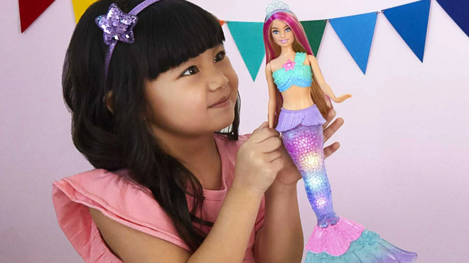 A girl playing with Barbie Dreamtopia Twinkle Fantasy Mermaid Doll