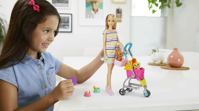 A girl playing with Barbie Pets Stroll Play Pups Playset