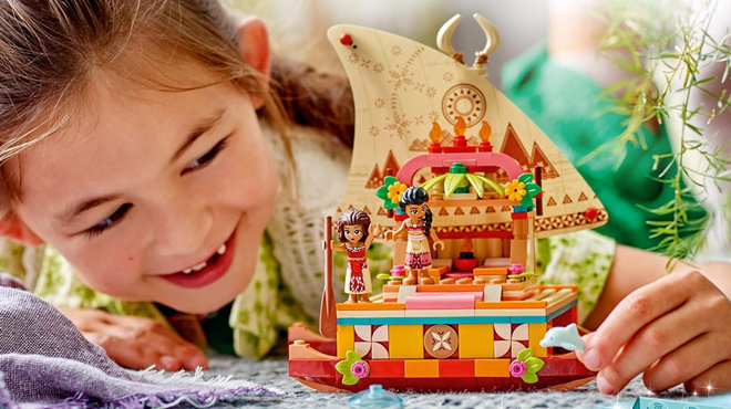 A girl playing with LEGO Disney Princess Moanas Boat Building Toy