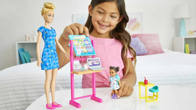 A girls playing with Barbie Careers Teacher Playset with Blonde Fashion Doll