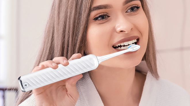 A lady brushing her teeth using Uningopi Electric Toothbrush with Water Flosser