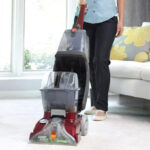 A person Using Hoover PowerScrub Deluxe Carpet Cleaner