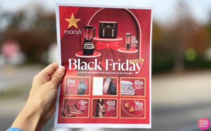 A person holding a Macys Black Friday Pamphlet