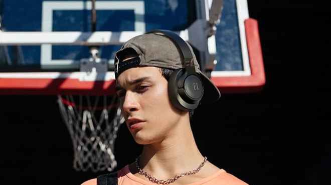 A person putting on a black JBL Tune 720BT Wireless Headphones