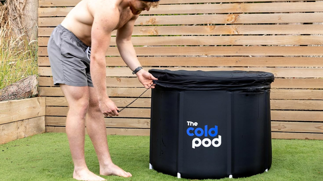 A person setting up The Cold Pod Ice Bath Tub for Athletes