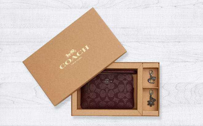 Coach Boxed Corner Zip Wristlet In Signature Canvas With Charms in the Box on the Table