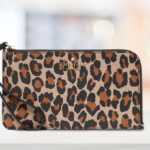 Kate Spade Leopard Medium L Zip Wristlet on a Table