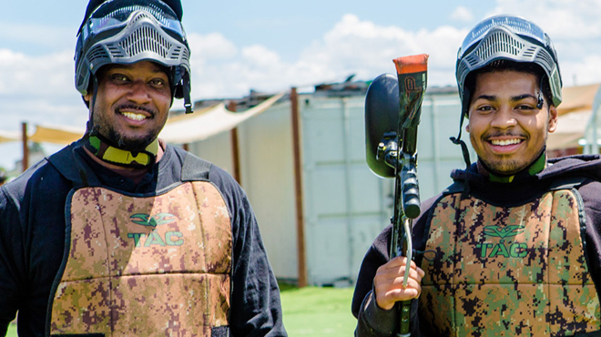 Two People wearing a complete Paintball Gear and holding a Paint Ball Gun