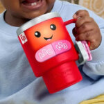 A Child Holding the Laugh Learn Red Coffee Cup